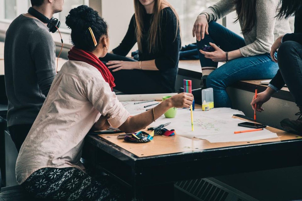 Diverse group of entrepreneurs planning together around a shared worktable