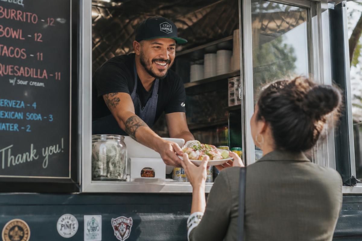 Food truck owner serving a customer at the window